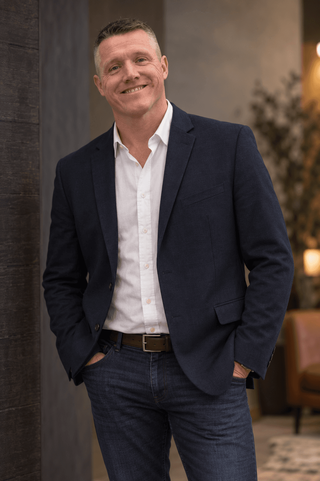 Jimmy Sechler in a warmly lit study, wearing a navy blazer and open collar